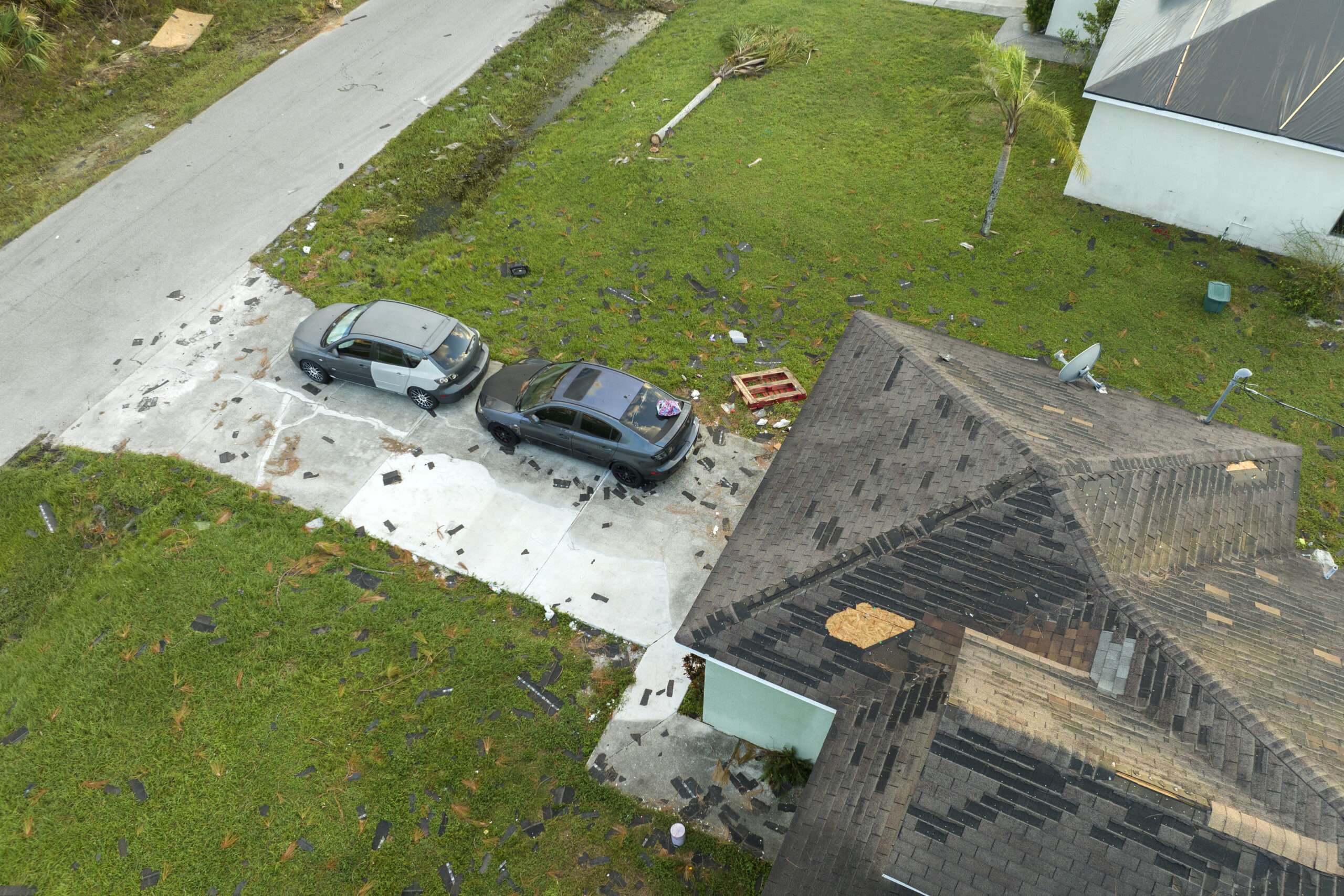 top view of damaged house and vehicles from a hail storm