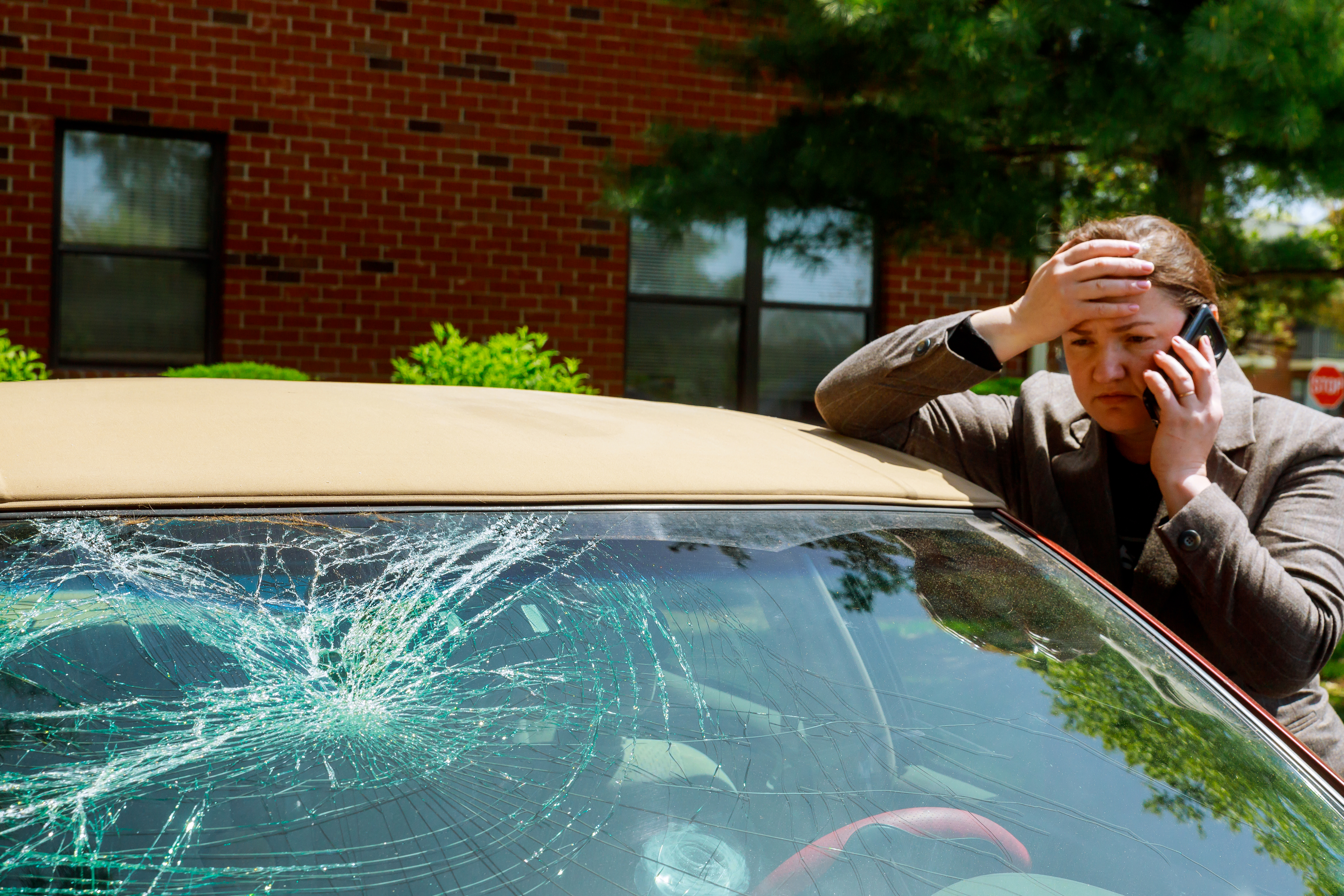 men working on a white automobile for hail damage in a shop denver colorado